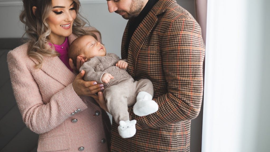 Mother and father holding their young baby boy in their hands.